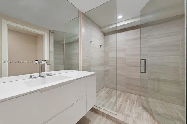 a bathroom with a sink shower and a mirror