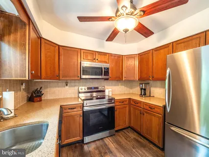 a kitchen with kitchen island granite countertop a sink stainless steel appliances and counter space