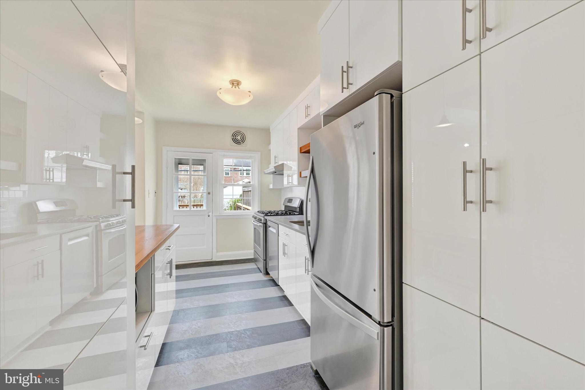 215 Regester Avenue Baltimore, MD 21212 - Photo 11 of 24 a kitchen with white cabinets and refrigerator