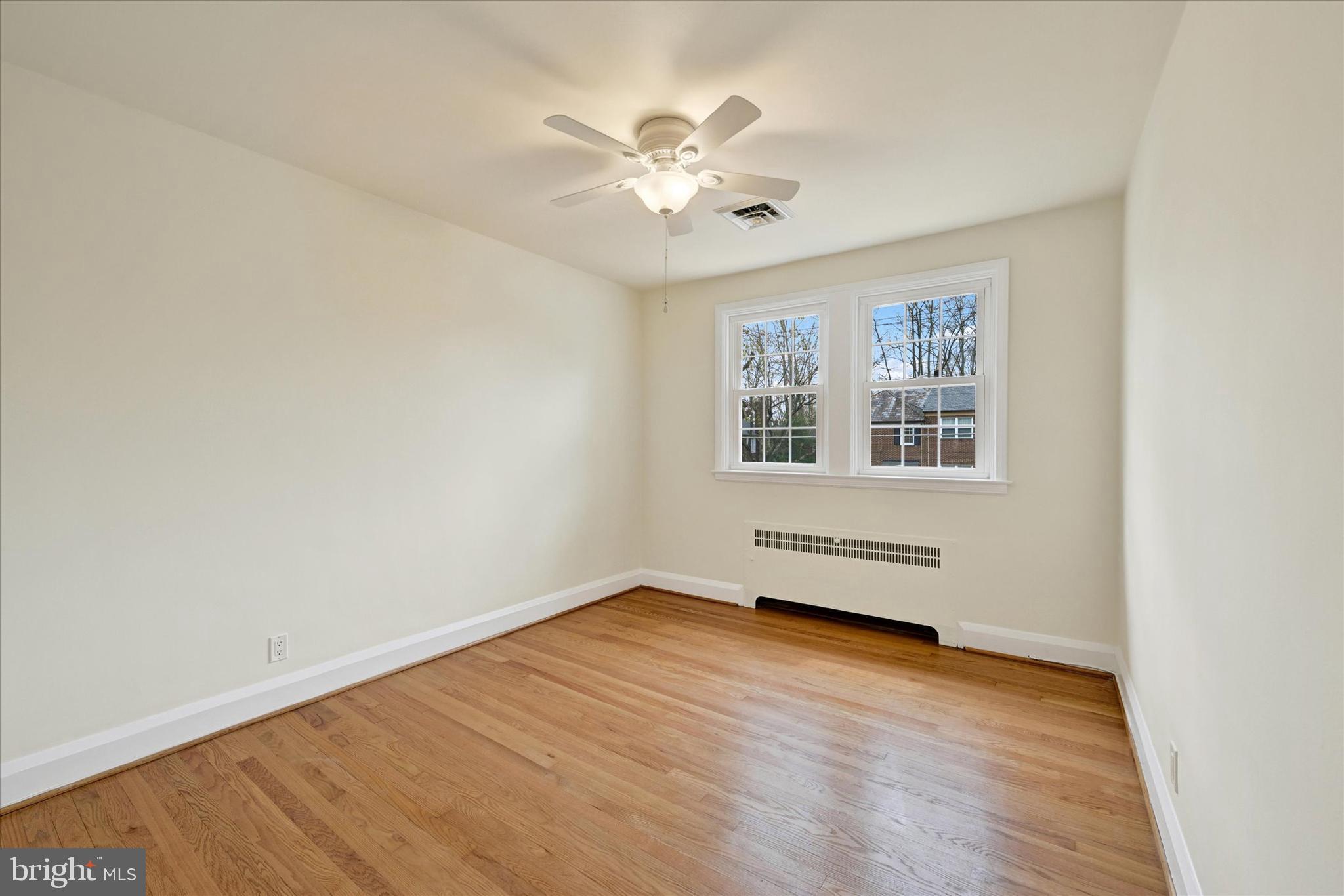 215 Regester Avenue Baltimore, MD 21212 - Photo 13 of 24 an empty room with wooden floor chandelier fan and windows