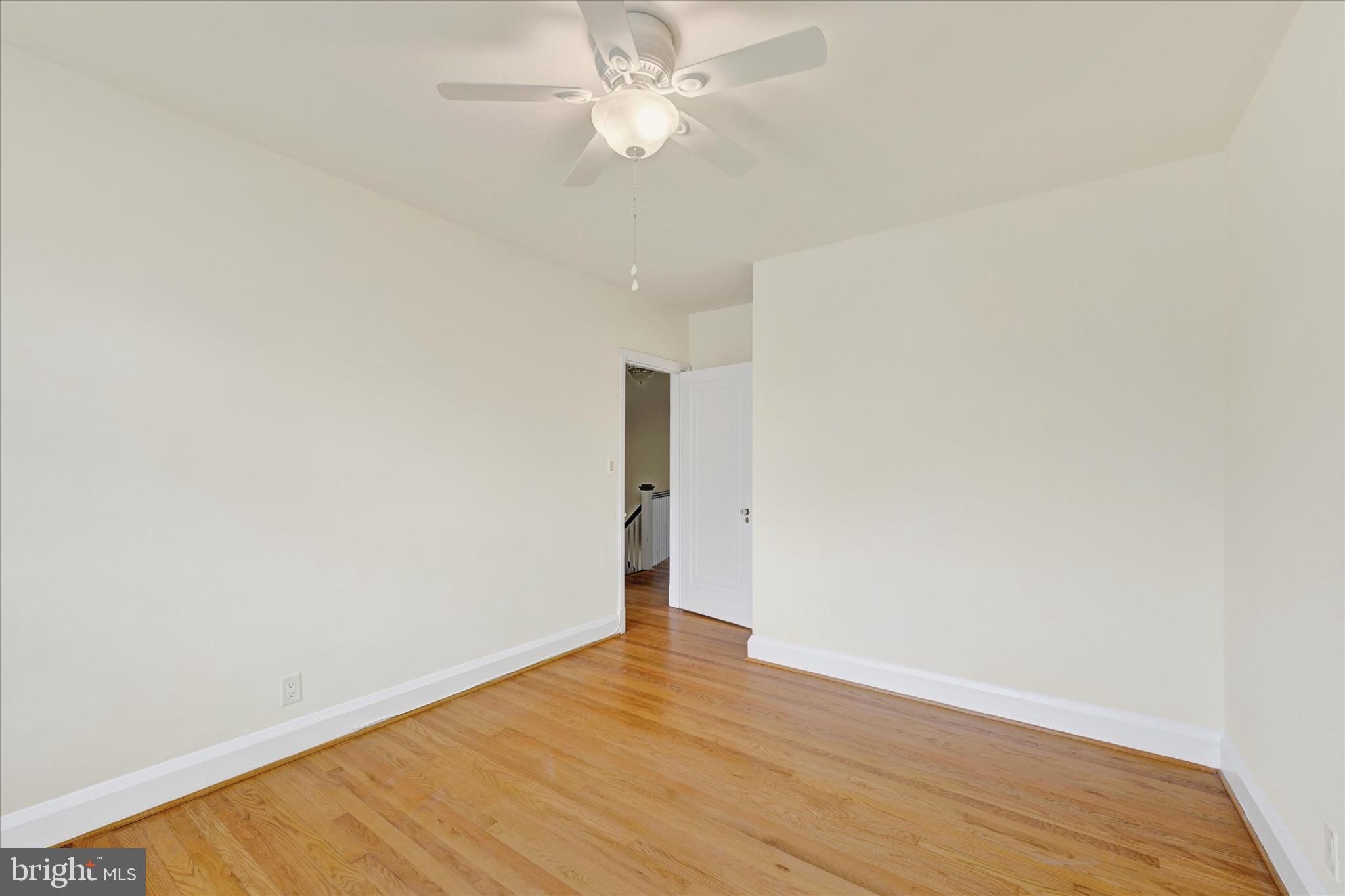 215 Regester Avenue Baltimore, MD 21212 - Photo 14 of 24 an empty room with wooden floor and fan