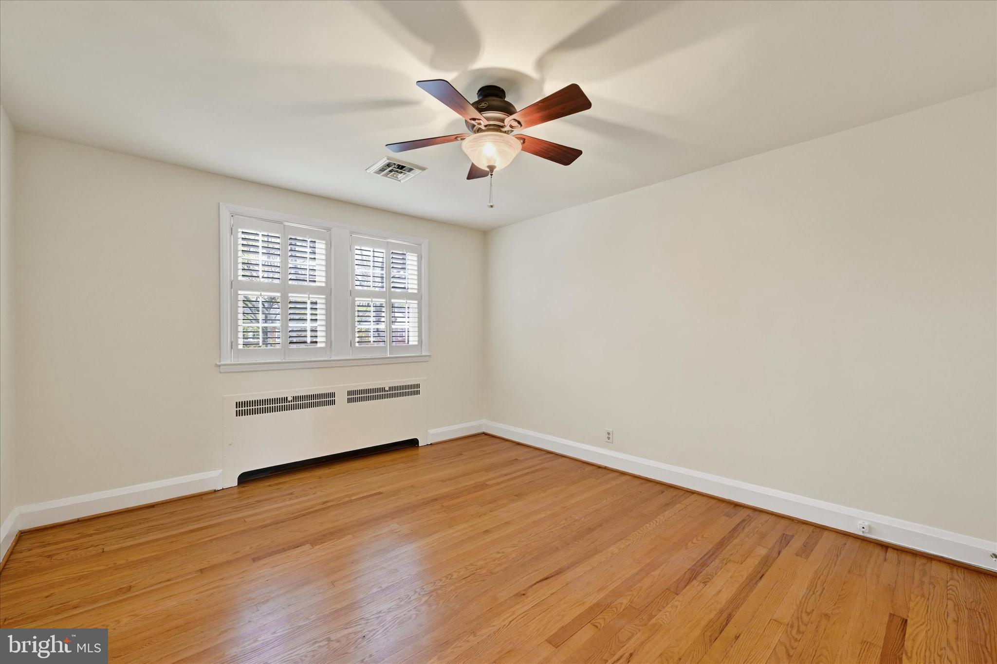 215 Regester Avenue Baltimore, MD 21212 - Photo 15 of 24 an empty room with wooden floor fan and windows