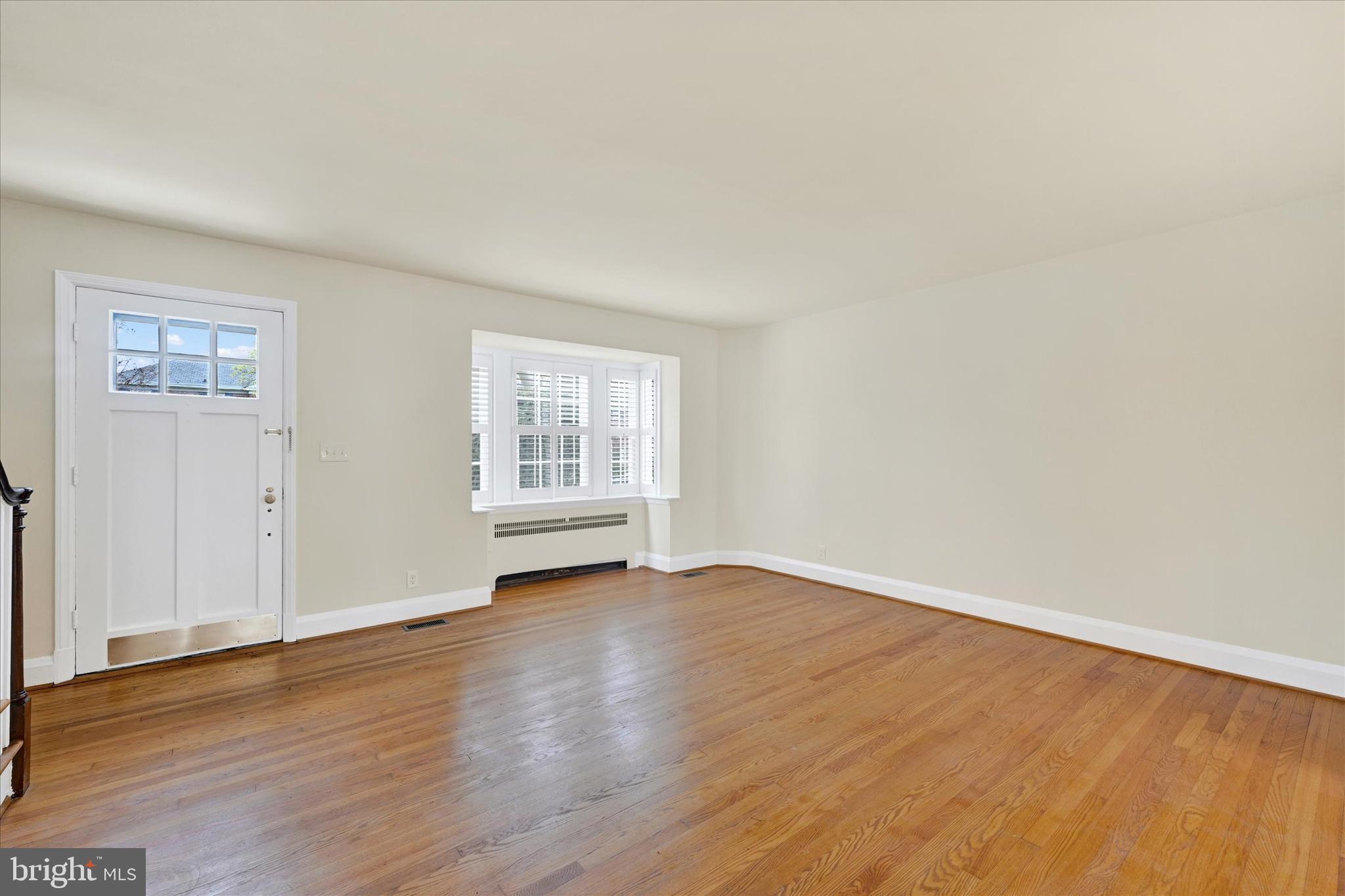 215 Regester Avenue Baltimore, MD 21212 - Photo 6 of 24 an empty room with wooden floor and windows