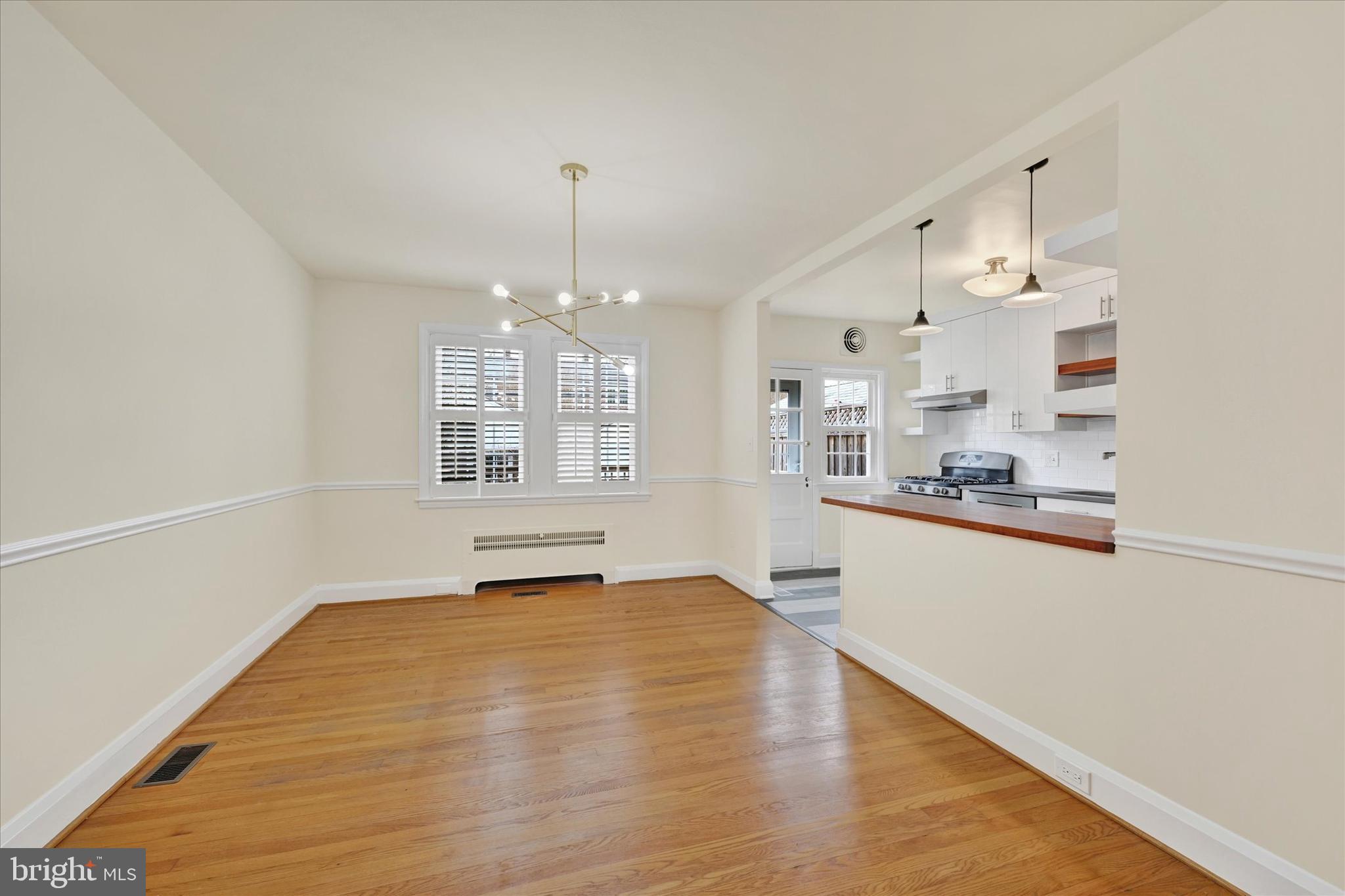 215 Regester Avenue Baltimore, MD 21212 - Photo 7 of 24 a view of a kitchen with kitchen island a sink wooden floor and a counter top space