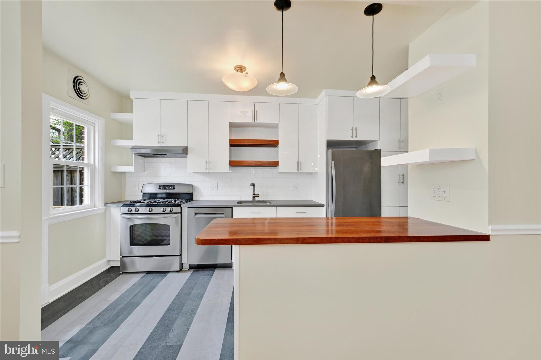 215 Regester Avenue Baltimore, MD 21212 - Photo 9 of 24 a kitchen with stainless steel appliances granite countertop a stove a sink and a refrigerator