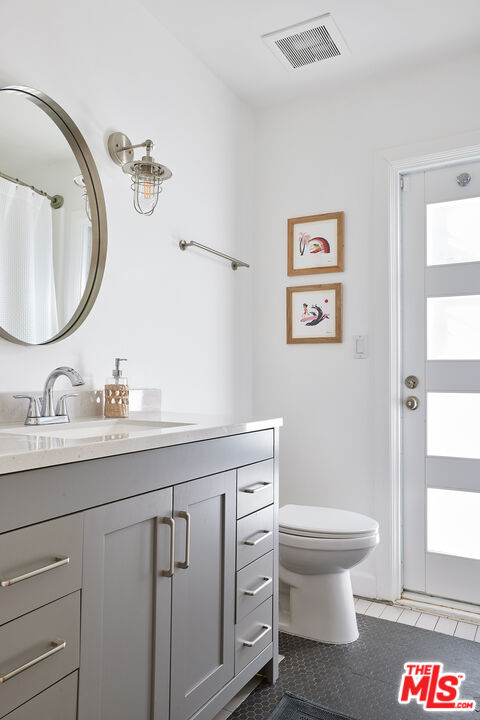 6637 Zumirez Drive Malibu, CA 90265 - Photo 18 of 29 a bathroom with a granite countertop toilet sink and mirror