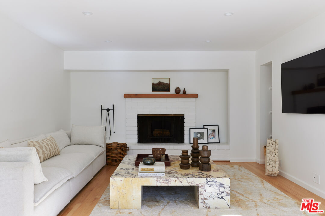 6637 Zumirez Drive Malibu, CA 90265 - Photo 22 of 29 a living room with furniture a flat screen tv and a fireplace