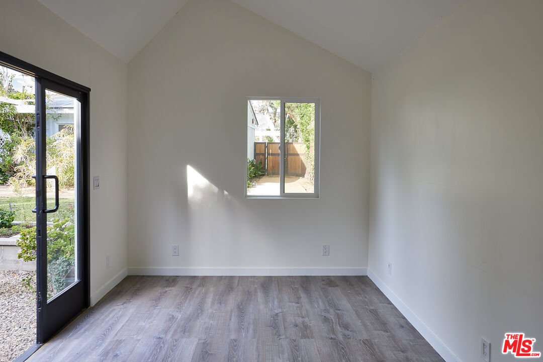 6637 Zumirez Drive Malibu, CA 90265 - Photo 25 of 29 an empty room with wooden floor and windows