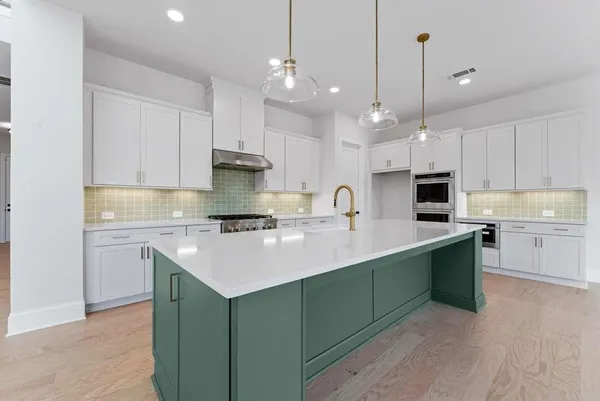 a kitchen with kitchen island a sink stainless steel appliances and cabinets