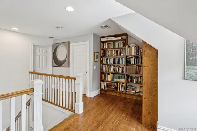 a view of a hallway with wooden floor and staircase