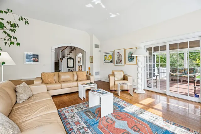 a living room with furniture large window and wooden floor