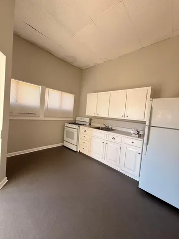 a kitchen with granite countertop white cabinets and white appliances