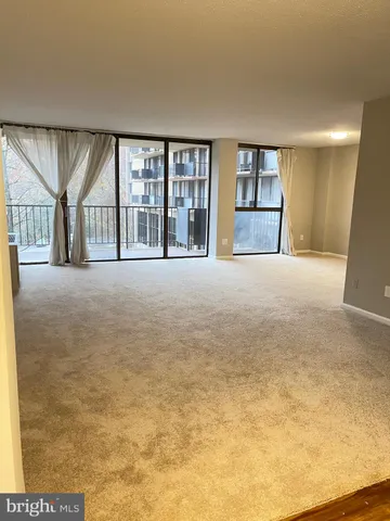 a view of an empty room with a fireplace and a window