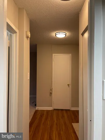 an empty room with wooden floor and a mirror