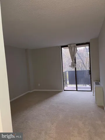 an empty room with a fireplace and large window