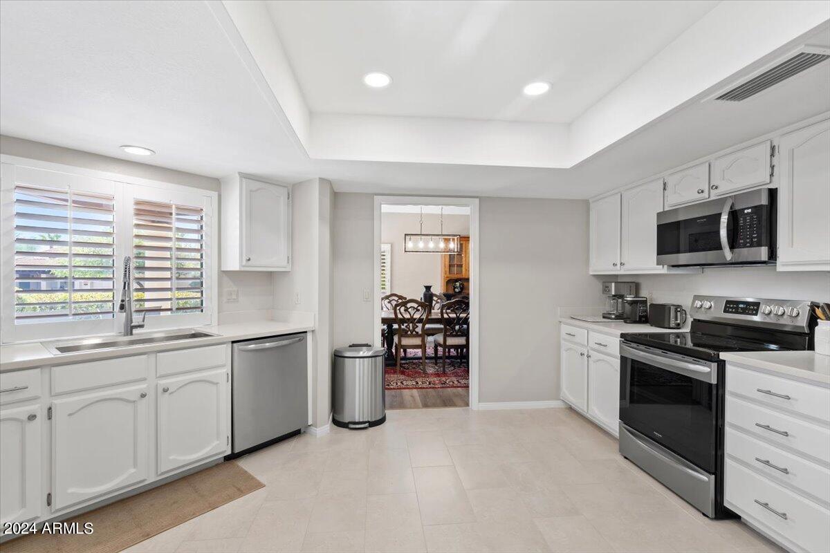 18425 East 4 Peaks Boulevard Rio Verde, AZ 85263 - Photo 14 of 75 a kitchen with stainless steel appliances granite countertop a stove top oven a sink dishwasher a microwave oven and a refrigerator with wooden cabinets
