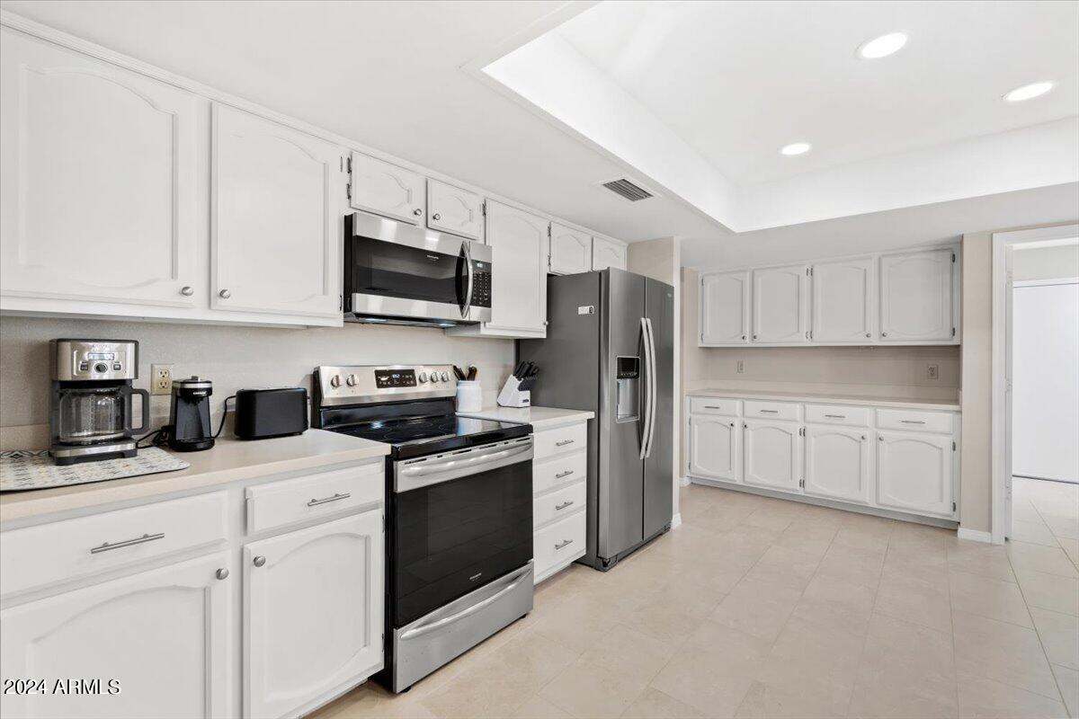 18425 East 4 Peaks Boulevard Rio Verde, AZ 85263 - Photo 17 of 75 a kitchen with stainless steel appliances granite countertop white cabinets a sink a stove a refrigerator and cabinets with wooden floor