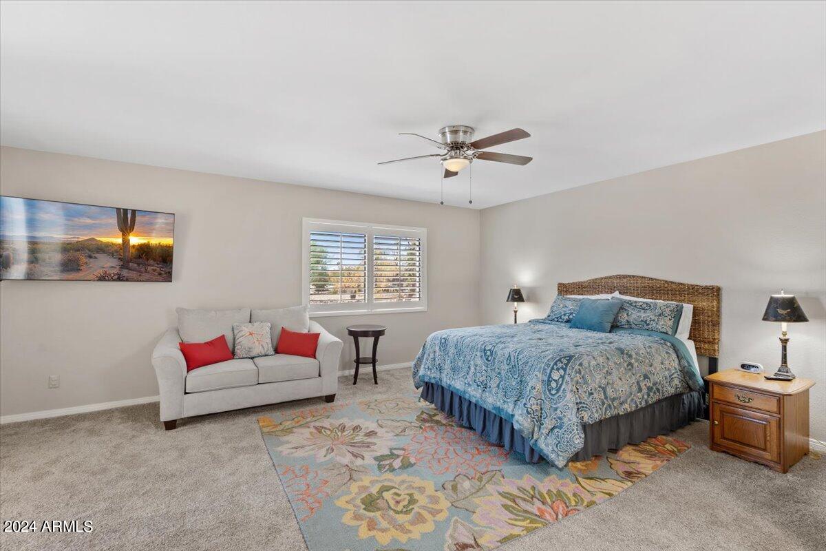18425 East 4 Peaks Boulevard Rio Verde, AZ 85263 - Photo 23 of 75 a spacious bedroom with a bed a couch and a window