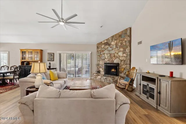 a kitchen with stainless steel appliances granite countertop a stove top oven a sink dishwasher a microwave oven and a refrigerator with wooden cabinets