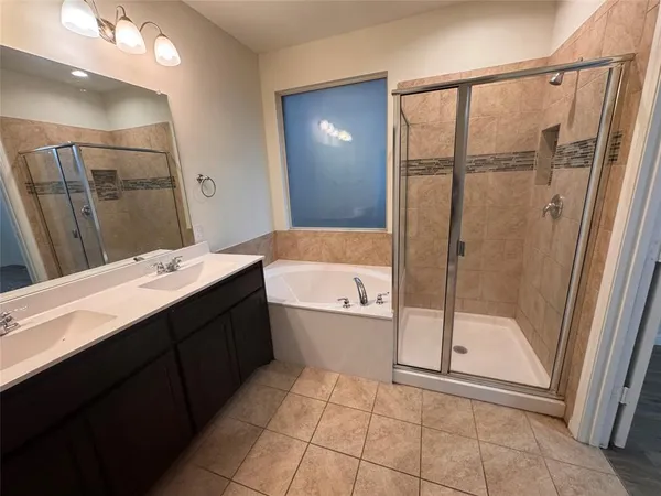 a bathroom with a double vanity sink a toilet and shower