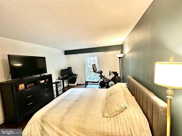 a bed room with a bed a television and a large window