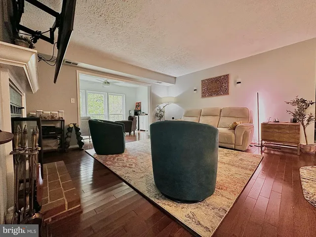 a living room with furniture a flat screen tv and a rug