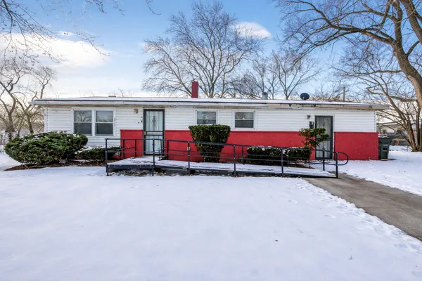 front view of house with outdoor space and large trees