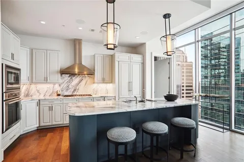 a kitchen with stainless steel appliances granite countertop a sink a stove and a wooden floor