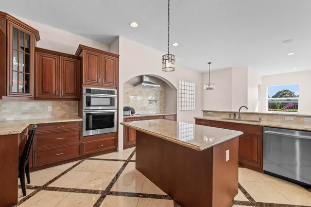 a kitchen with stainless steel appliances granite countertop a sink a stove and a refrigerator