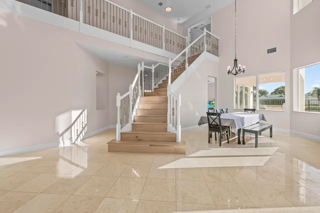 a dining room with wooden floor and a chandelier