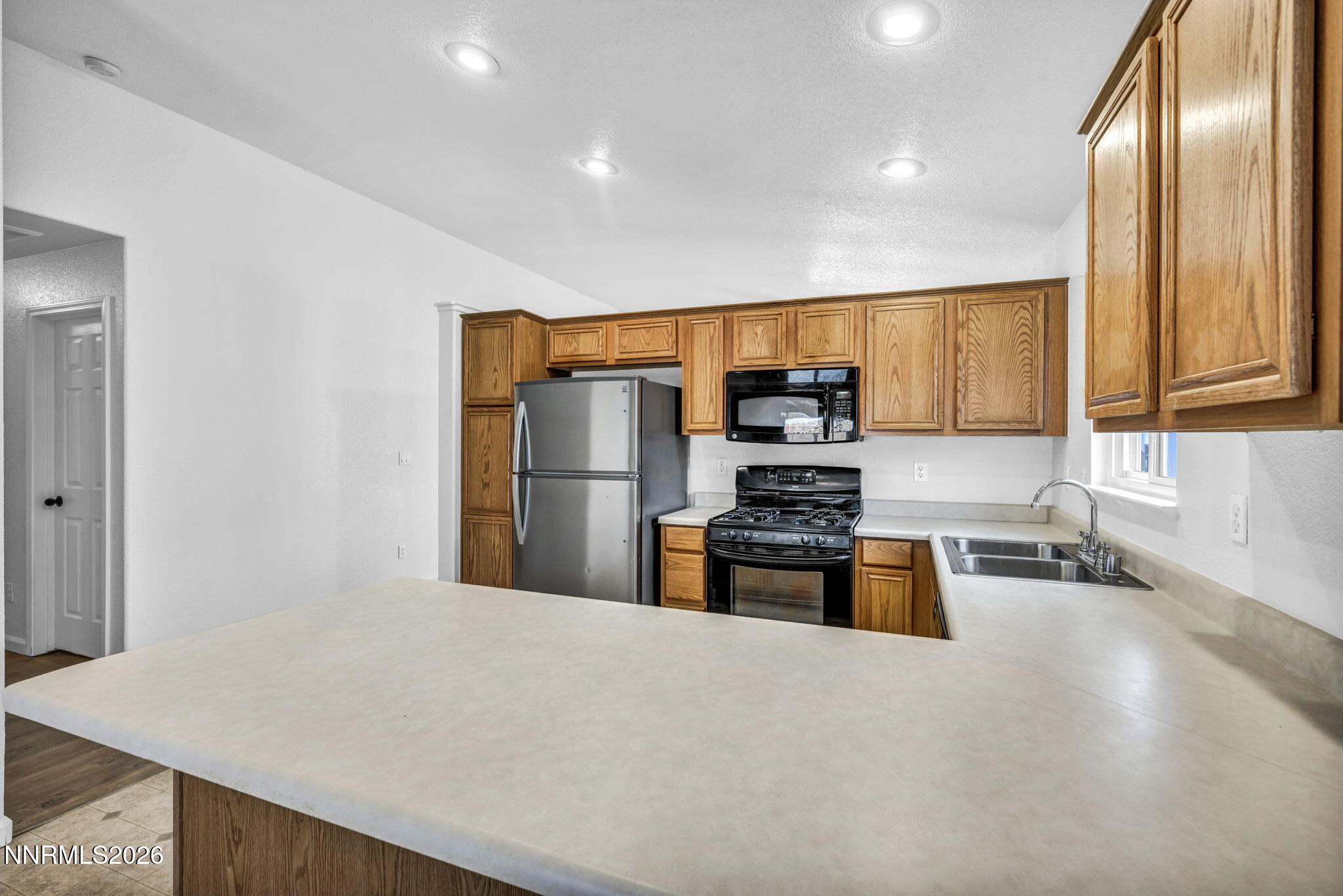 17725 Live Oak Court Reno, NV 89508 - Photo 28 of 44 a kitchen with stainless steel appliances granite countertop a refrigerator a stove and a sink with wooden floor