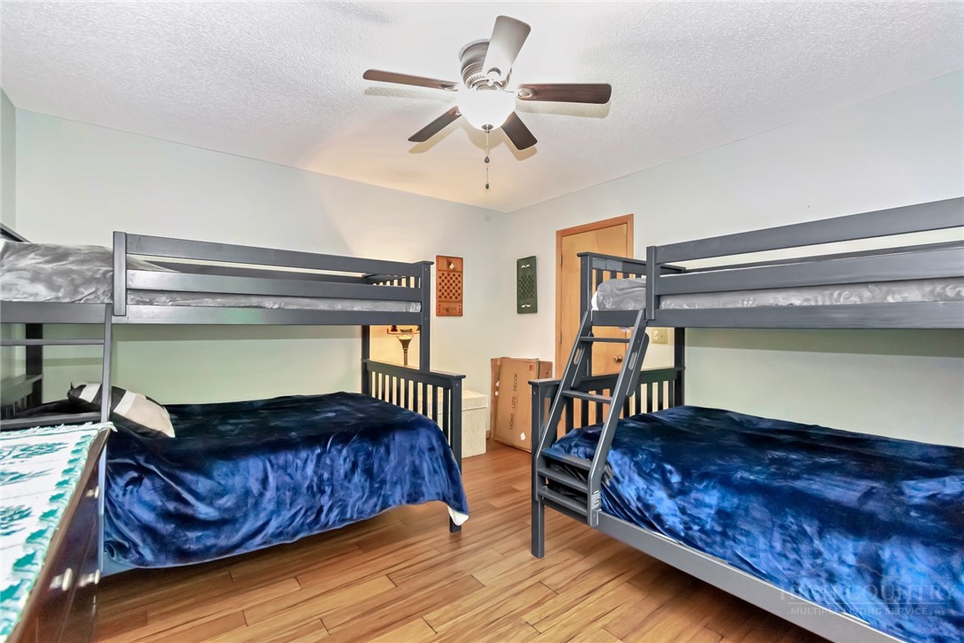 1078 Charter Hills Road Beech Mountain, NC 28604 - Photo 20 of 50 a bedroom with a bed and a chandelier