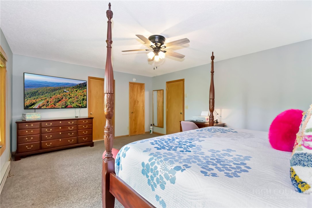 1078 Charter Hills Road Beech Mountain, NC 28604 - Photo 28 of 50 a bedroom with a bed dresser and a chandelier