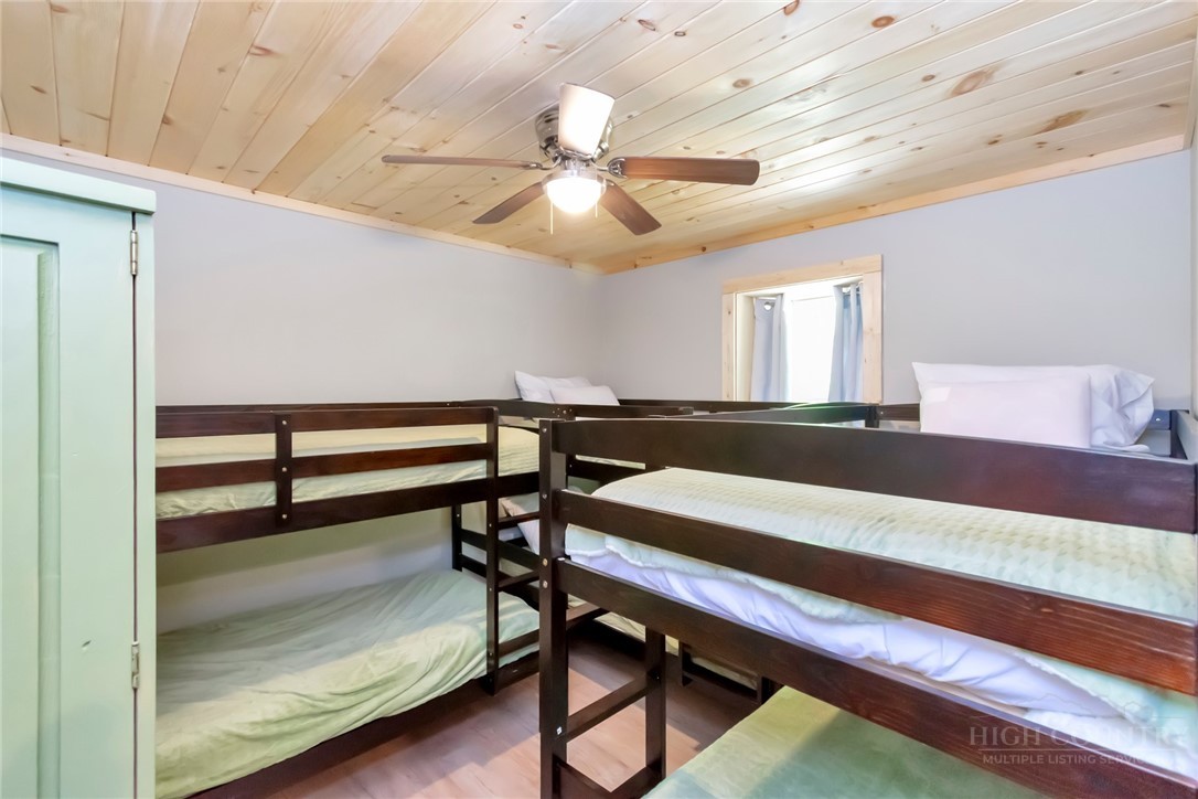 1078 Charter Hills Road Beech Mountain, NC 28604 - Photo 40 of 50 a bedroom with a bed and a chandelier