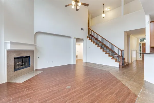 a view of an empty room with wooden floor a fireplace