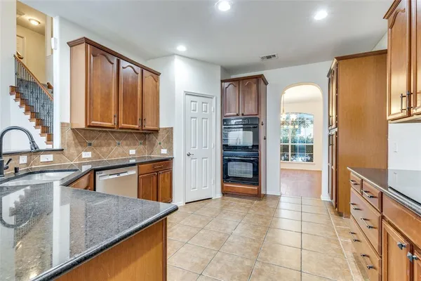 a kitchen with stainless steel appliances granite countertop a refrigerator and a sink