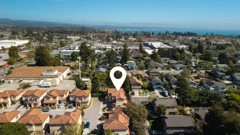 an aerial view of house with yard swimming pool and ocean view
