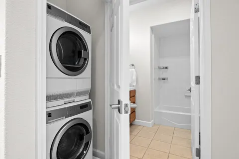 a view of a white house with large windows and a small yard