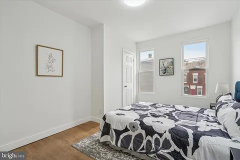 a bedroom with a bed and wooden floor