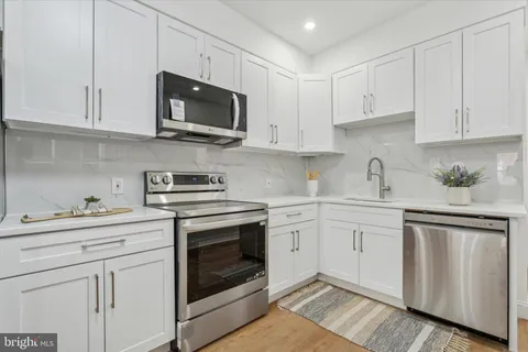 a kitchen with white cabinets stainless steel appliances and sink