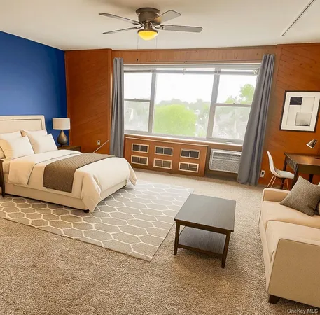 a bedroom with a bed and a couch with large windows