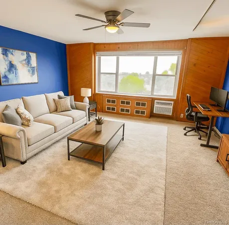 a living room with furniture gym equipment and a large window