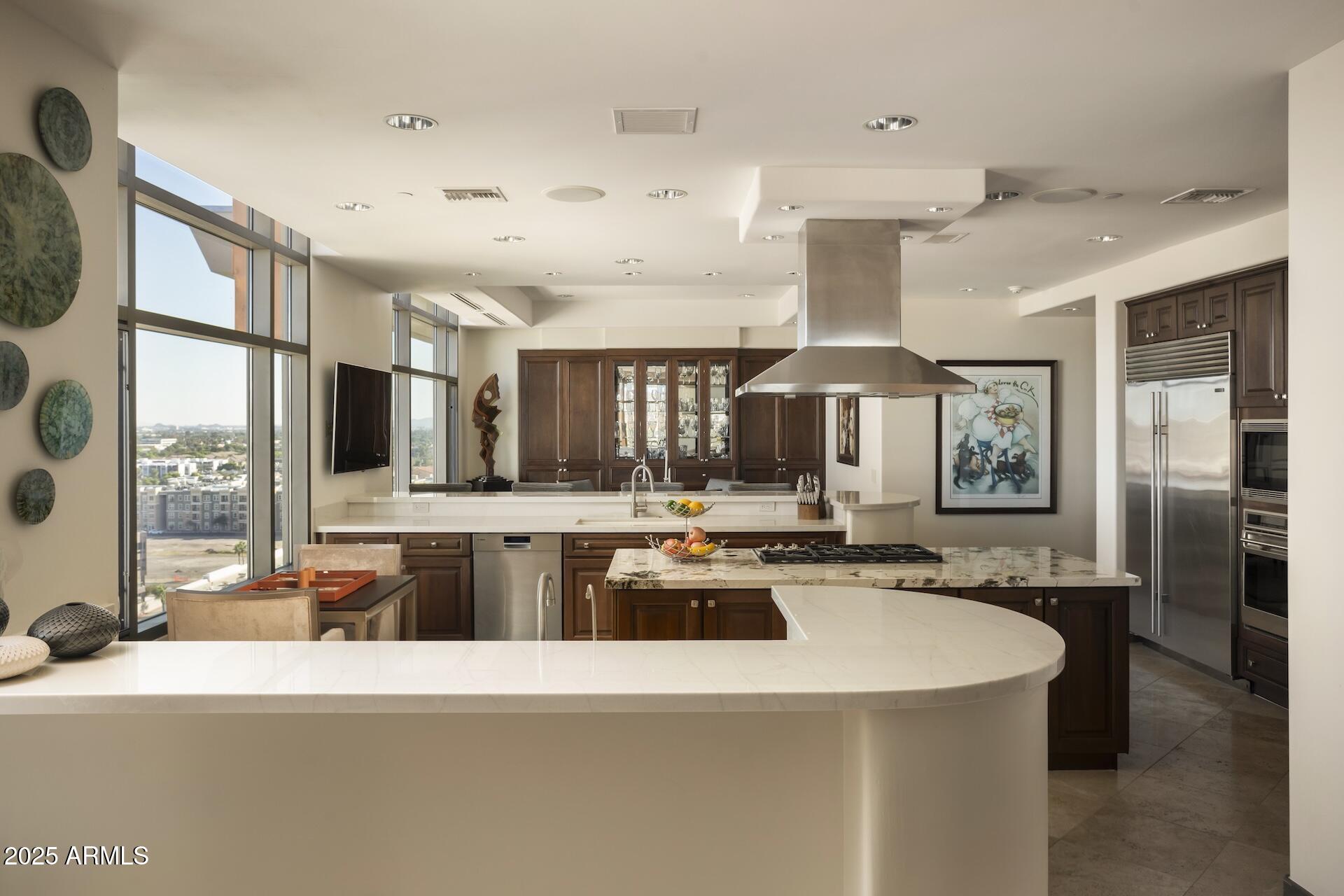 2211 East Camelback Road, Unit 1203 Phoenix, AZ 85016 - Photo 11 of 39 a kitchen with stainless steel appliances granite countertop a sink and a refrigerator