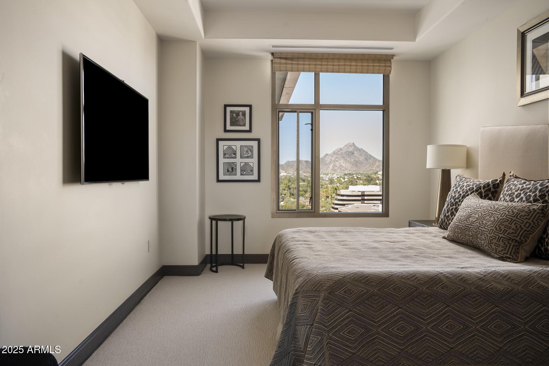 2211 East Camelback Road, Unit 1203 Phoenix, AZ 85016 - Photo 20 of 39 a bedroom with a bed and a flat tv screen next to a window