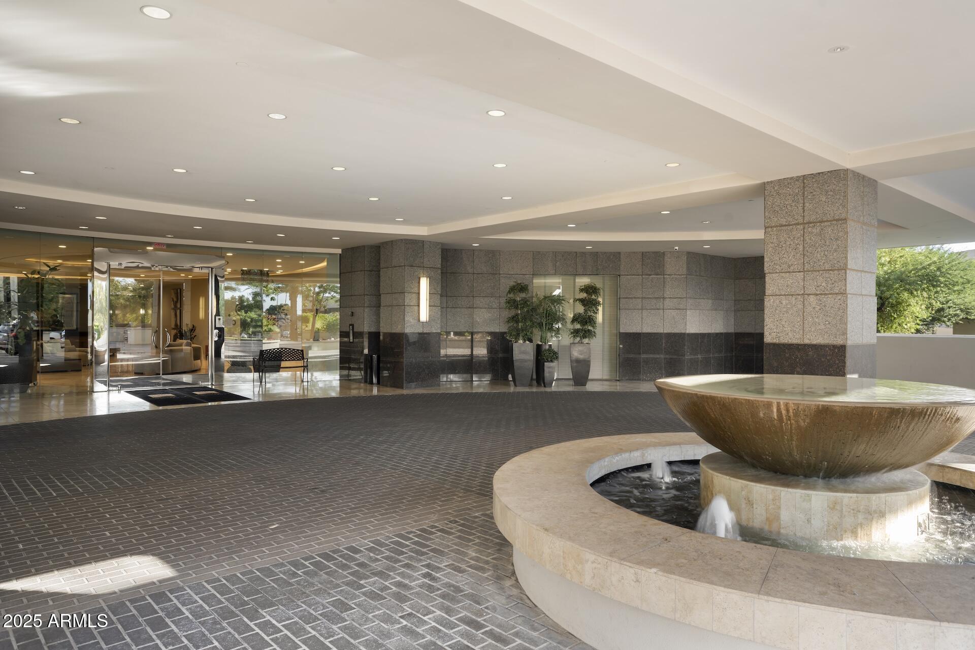 2211 East Camelback Road, Unit 1203 Phoenix, AZ 85016 - Photo 38 of 39 a living room with a couch and a potted plant