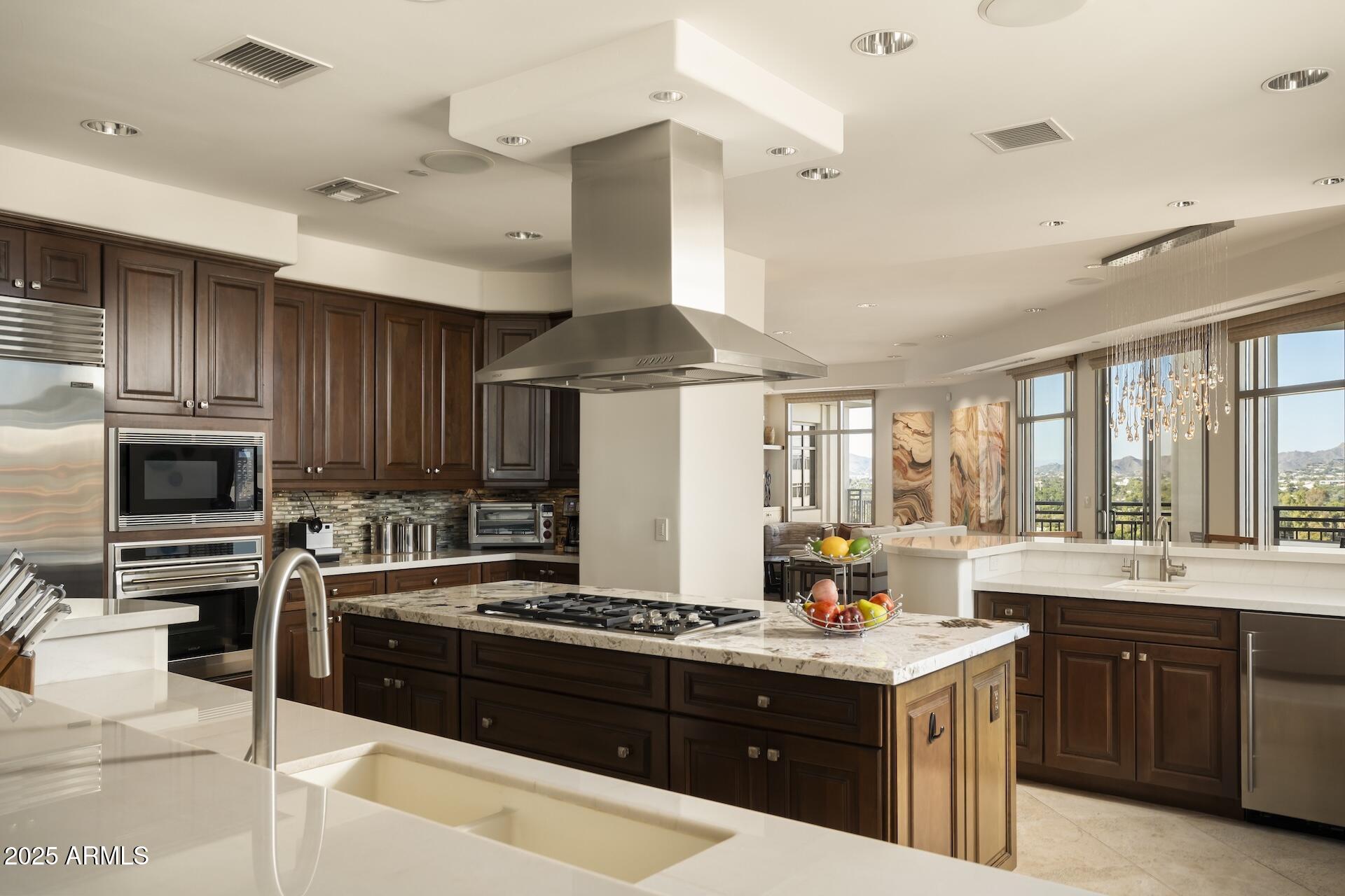 2211 East Camelback Road, Unit 1203 Phoenix, AZ 85016 - Photo 8 of 39 a kitchen with kitchen island granite countertop a sink stove and refrigerator