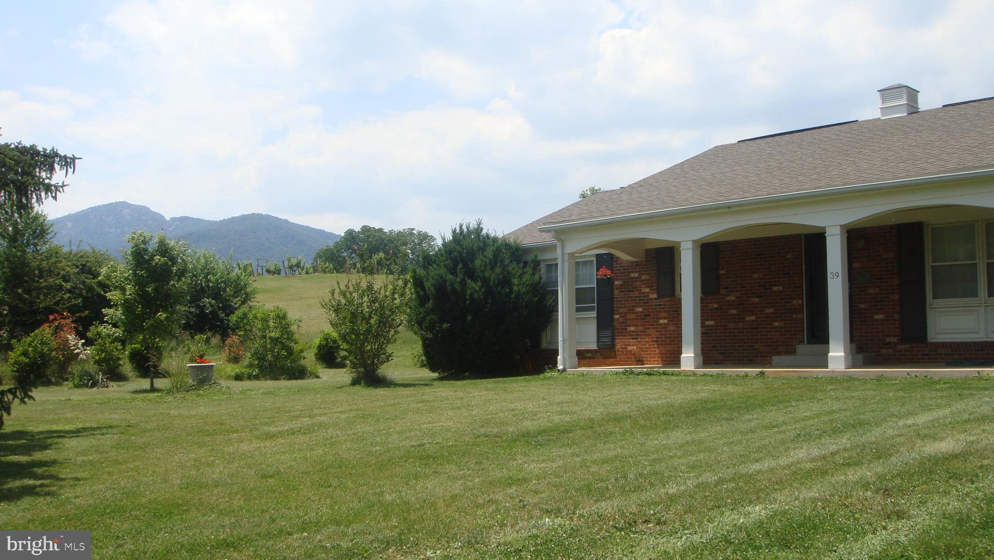 39 Sharp Rock Road Sperryville, VA 22740 - Photo 9 of 21 a view of a white house with a big yard and large trees