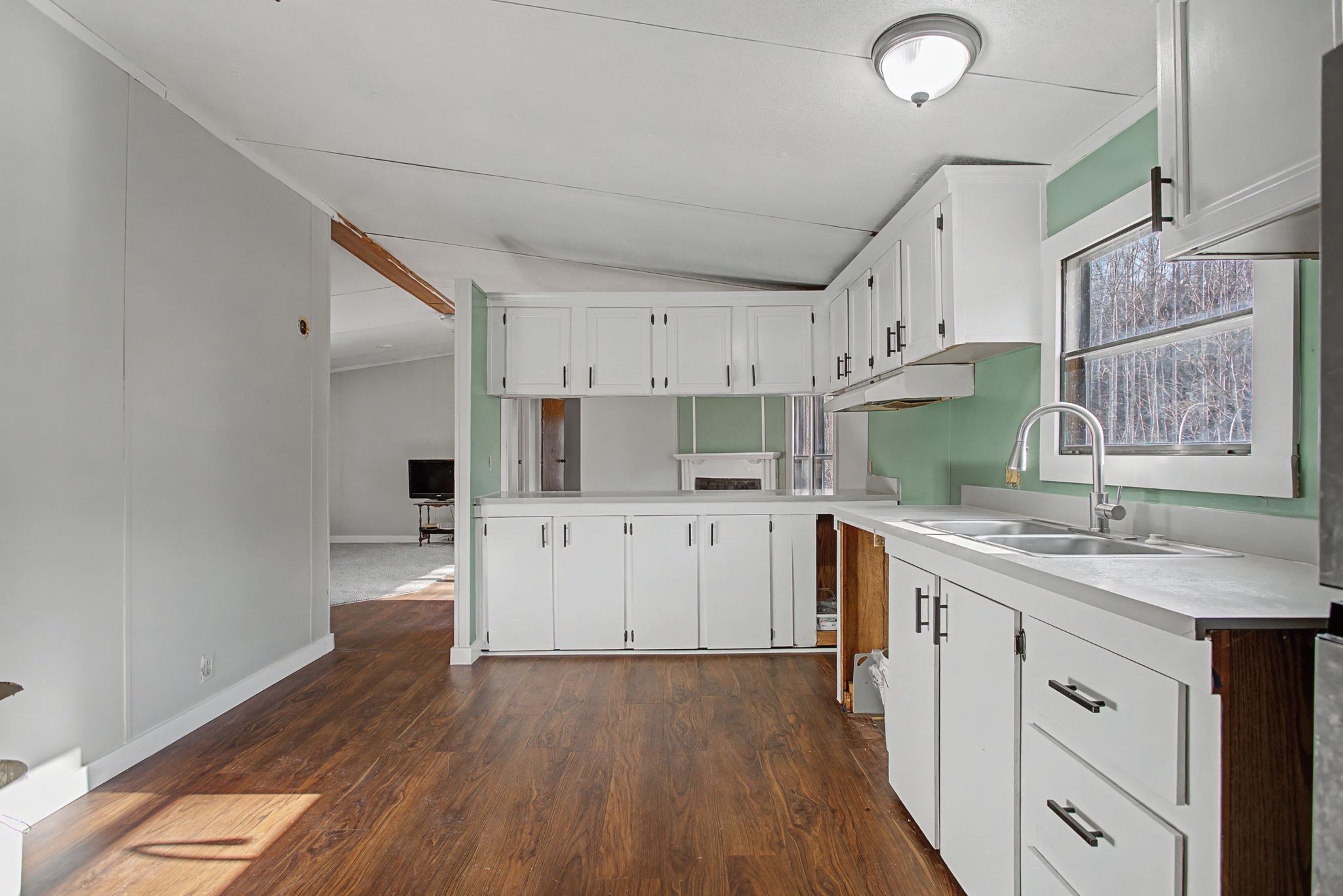 405 Napier Road Hohenwald, TN 38462 - Photo 6 of 37 a kitchen with kitchen island granite countertop a sink cabinets and wooden floor