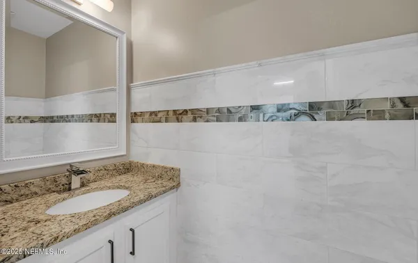 a bathroom with a granite countertop sink and a mirror