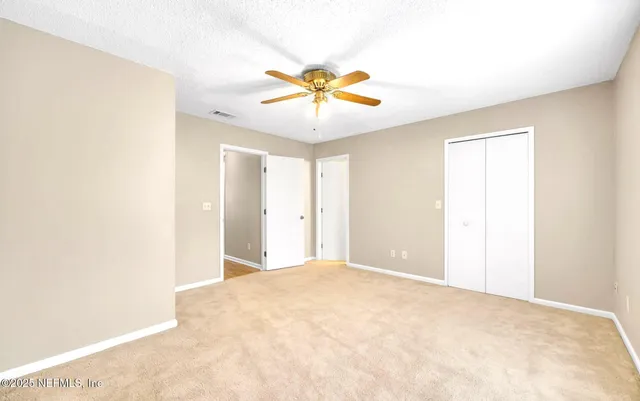 a view of a big room with a ceiling fan and a window